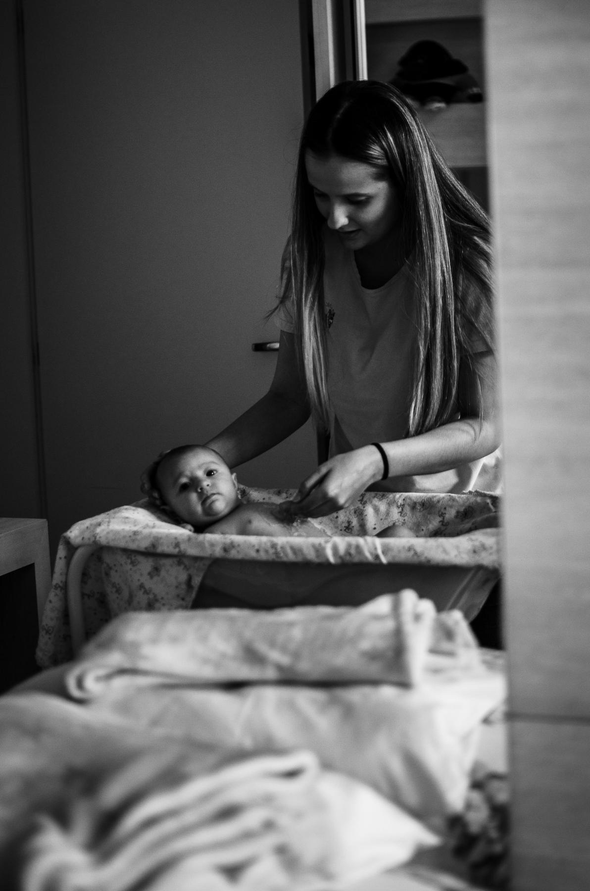 A mother dressing her newborn